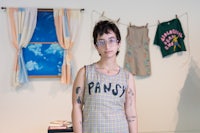 a woman in a plaid dress standing in front of clothes