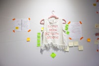 a white t - shirt hanging on a wall with notes on it