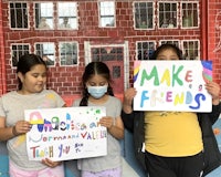 three girls holding up signs that say make friends