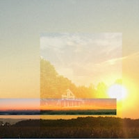 a picture of a house in a field at sunset