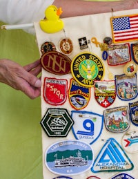 a woman is holding a flag with a lot of patches on it