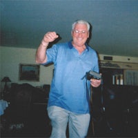 a man standing in a living room holding a wii remote